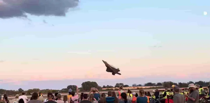 Image of low flying jet tilting up toward the clouds