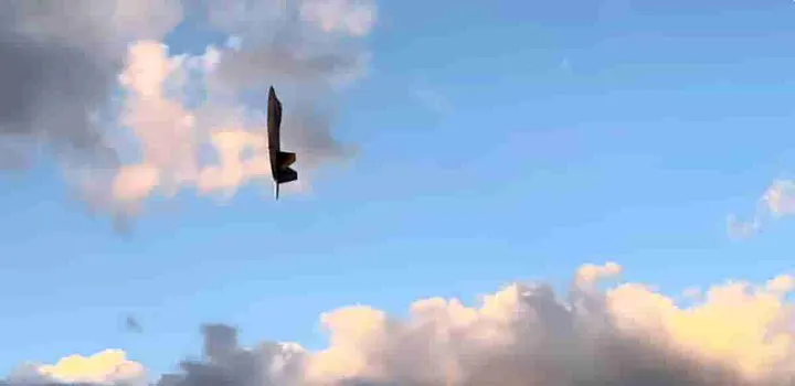 Military jet flying straight up with afterburners on