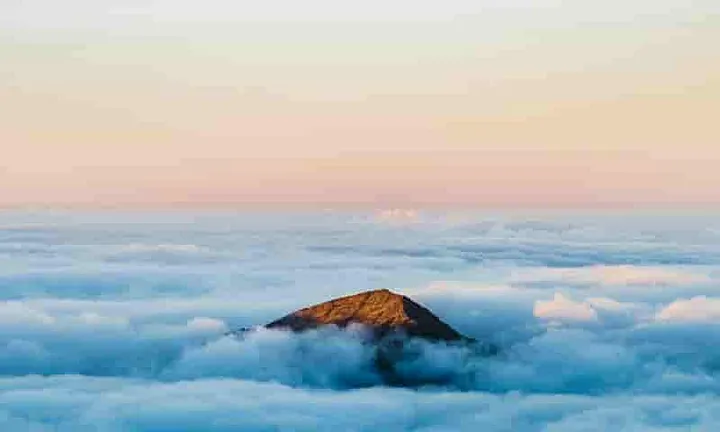 Image of the cloudy fog burning off in the morning sun, revealing the mountain peaks one by one