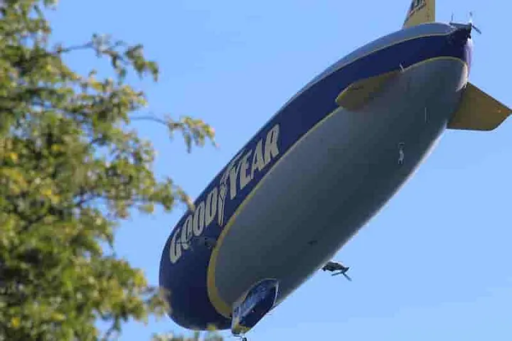  Goodyear Blimp about 120 feet overhead, very close to a tree
