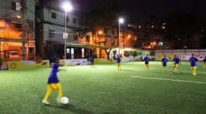 Kids playing soccer on a field with kinetic tiles placed under the turf