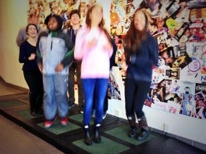Kids jumping up and down on Kinetic Tiles in their school