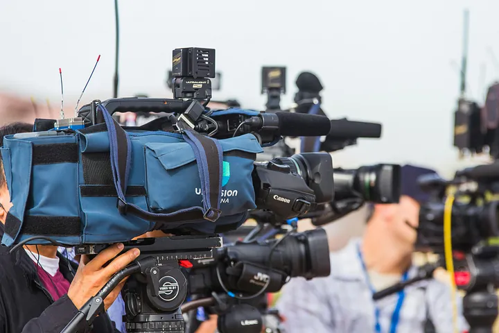 Image of reporters and cameras at a media event